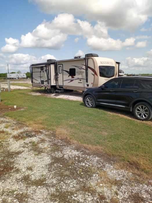 Rockwood travel trailer at a full hook-up 30/50-amp gravel RV site at Double Time RV Park in Alvin, Texas