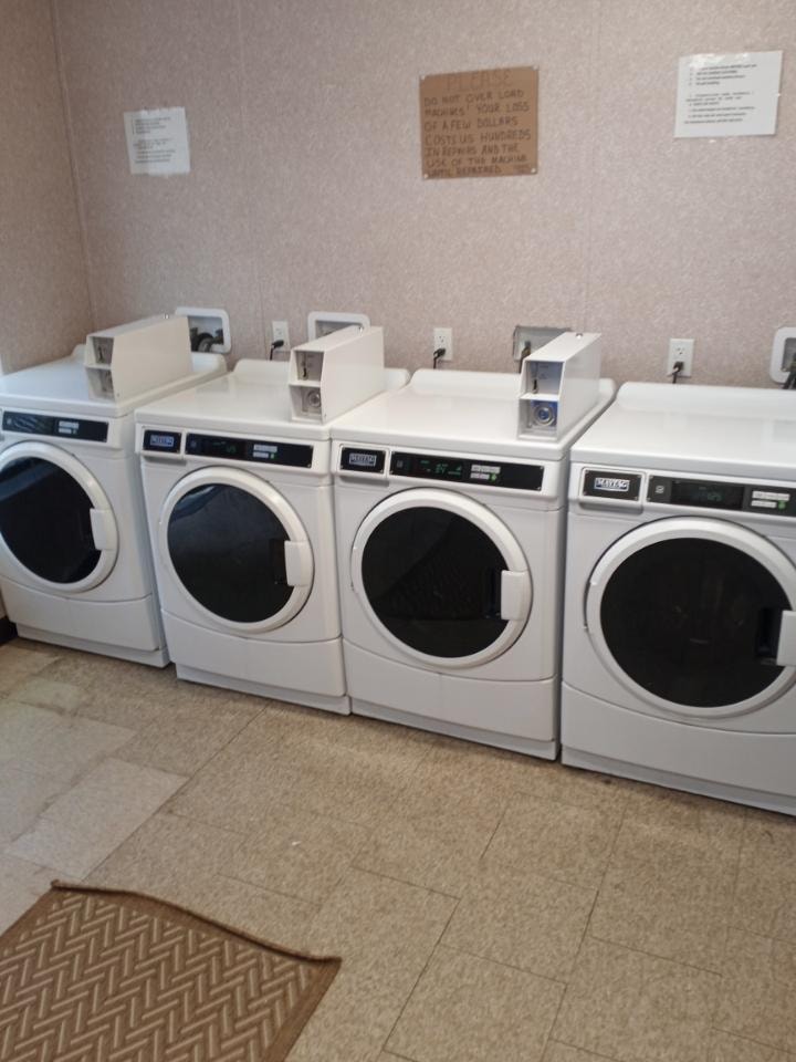 Coin-operated washer and dryer machines in the on-site 24-hour laundry room at Double Time RV Park — Alvin TX monthly RV park amenities